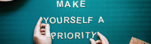 Hands spelling out with letters "Make Yourself a Priority"