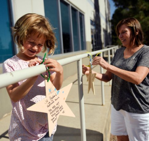HIGHLANDS RANCH, CO - AUGUST 6: 5 year old Sofia Kruus tying on a star will be starting kindergarten at the STEM School Highlands Ranch with her mother Jennifer hanging wooden stars that members of the community and people all over the country have decorated in order to support STEM students coming back to school August 6, 2019 in Highlands Ranch, Ohio (Photo by Joe Amon/The Denver Post)